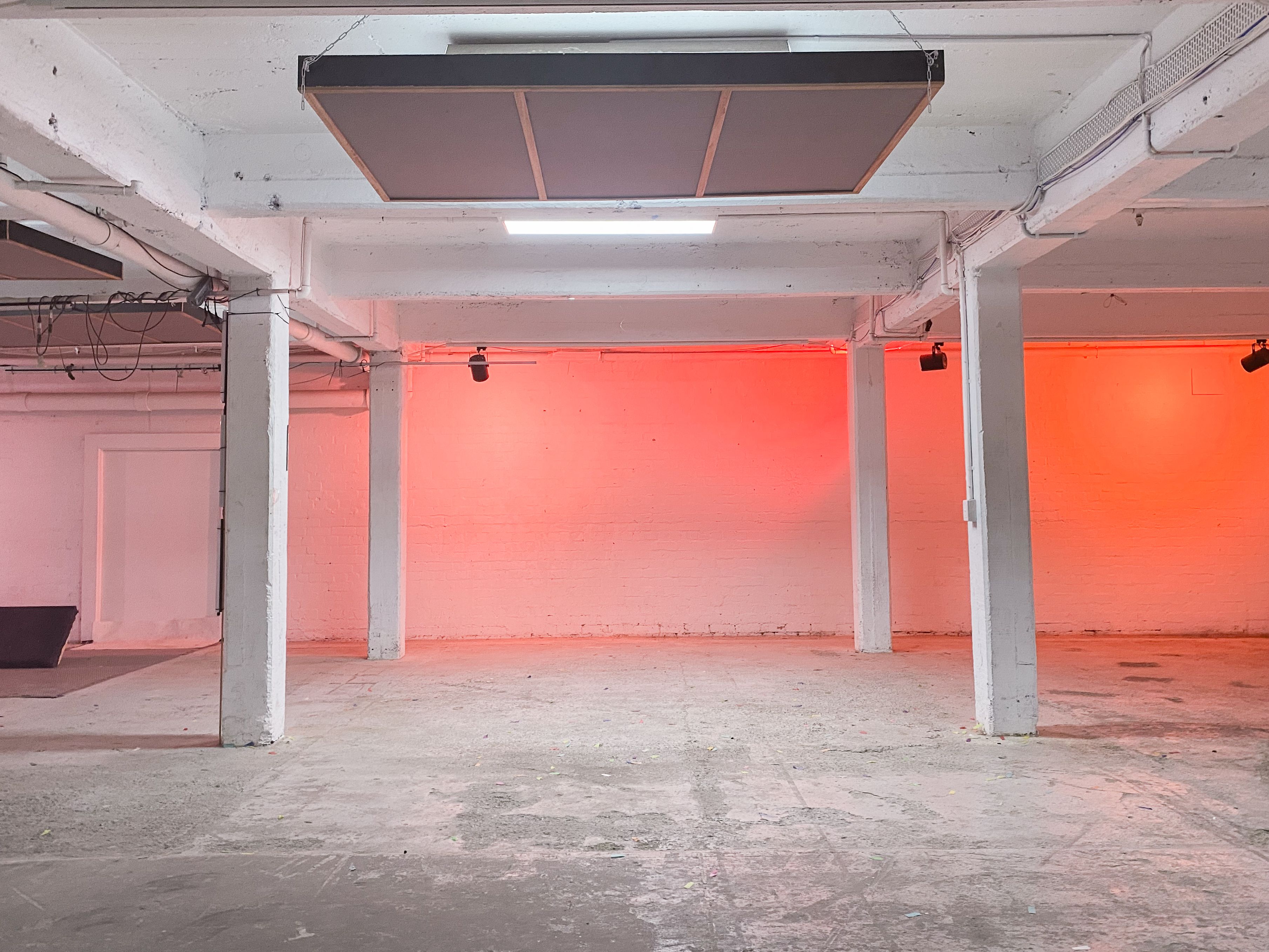 Interior-of-white-concrete-factory-four-beams-with- pink-backlighting-on-facing-wall